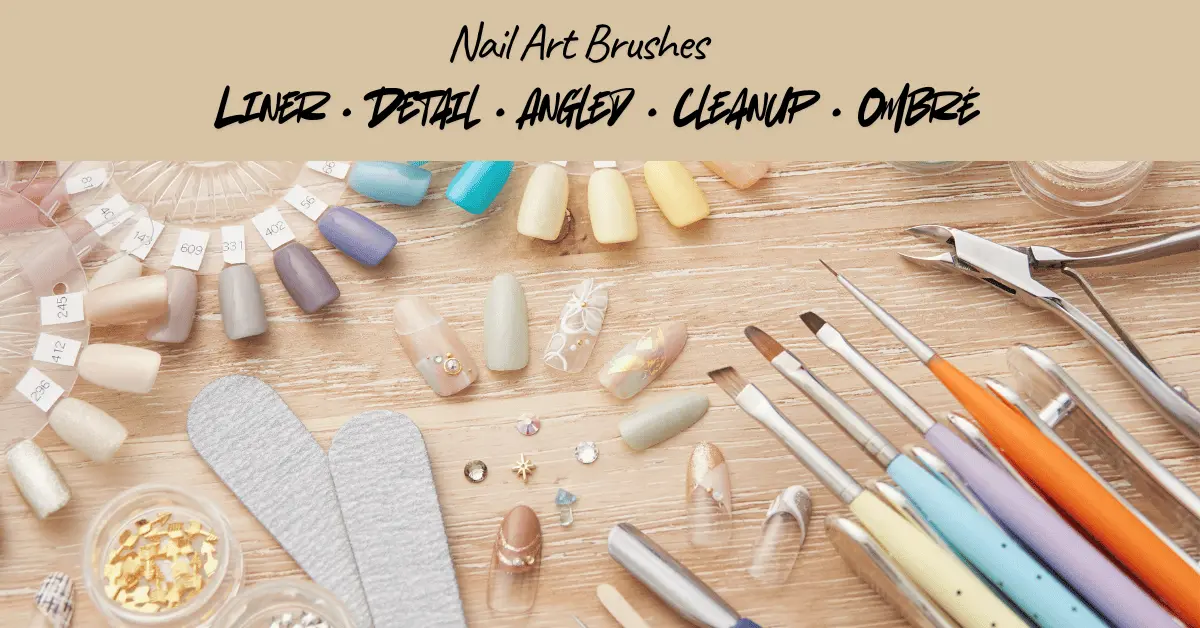Nail art brushes and manicure tools on a wooden table with nail polish swatch wheels and glitter jars.