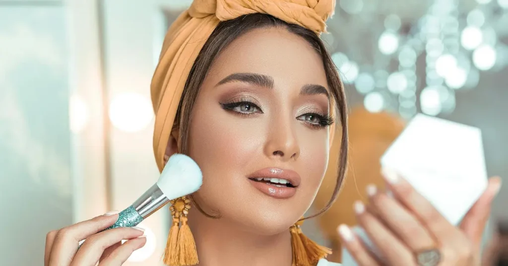 Woman applying face powder with a brush to set makeup after sunscreen and foundation.